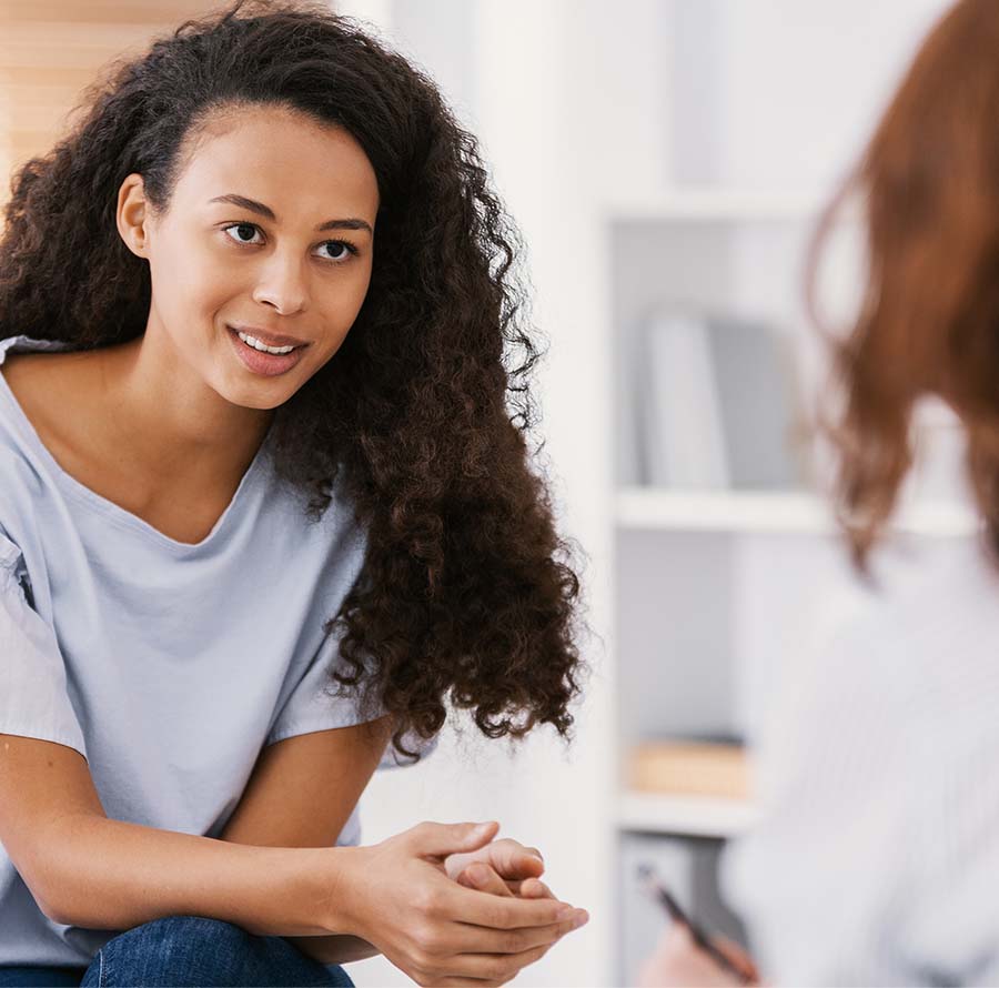 Image of women with curly hair speaking with another person. This image represents a session of sex therapy for sexual anxiety. You too can start working with a Christian sex therapist in Atlanta, GA for support. | 30024 | 30097