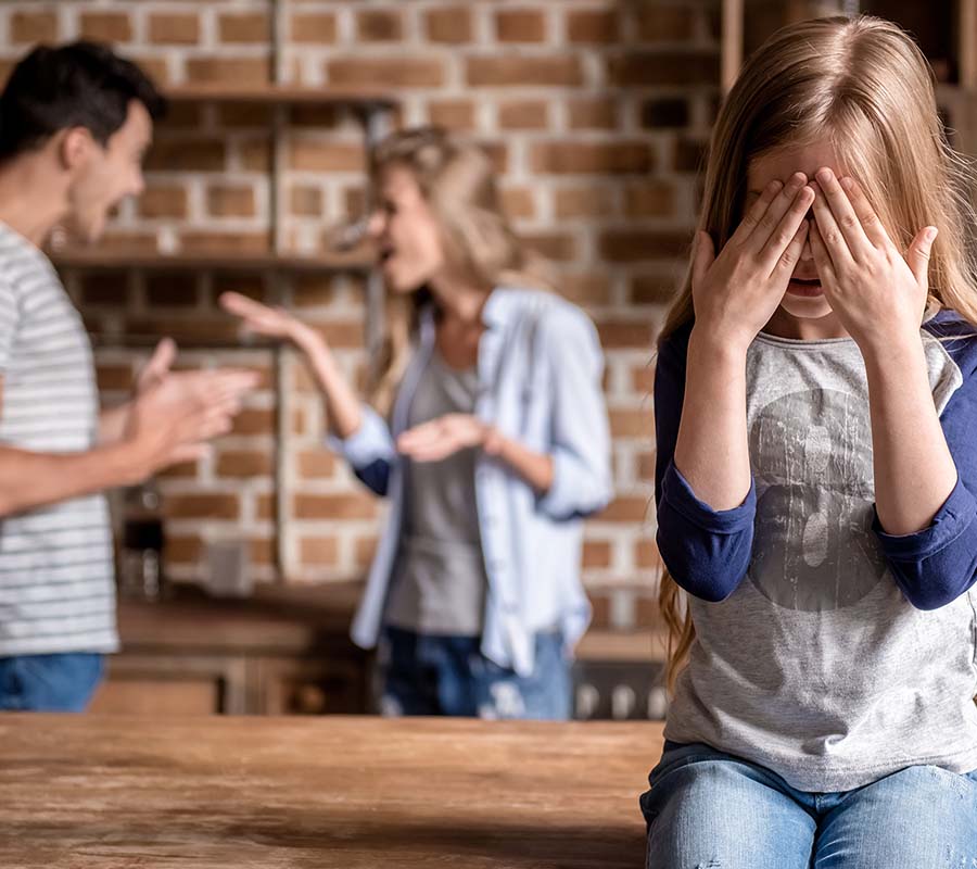 Image of child crying with couple fighting in the background. This image could depict a couple in need of divorce counseling in Atlanta, GA. Learn about coparenting and more with a divorce counselor. | 30024 | 30097