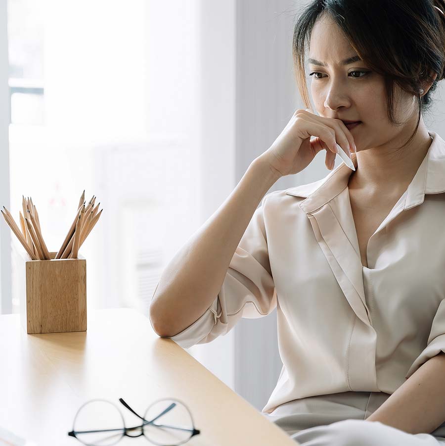 Image of a person sitting at a desk with pencils and glasses next to them. This image represents the focus partners exercise with a discernment therapist in Atlanta, GA when discussing divorce. Get help in discernment counseling and coparenting counseling here. | 30041 | 30043 | 30005