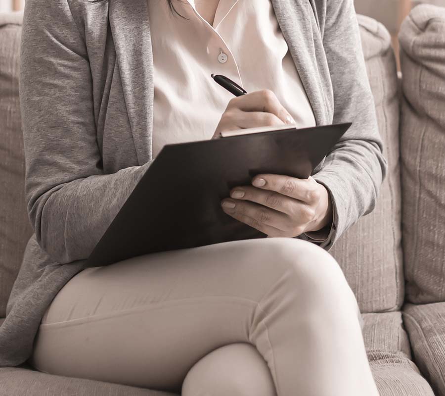Image of a person writing on a clipboard. This image could depict a marriage counselor in Gwinnett county, ga providing premarital counseling to a couple. | 30005 | 30097